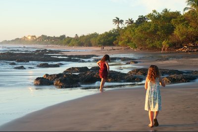 Couple walking the empty sand at Playa Avellanas, Guanacaste, at sunset