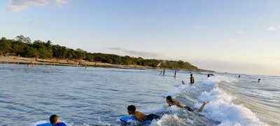 Beginner surfers in the whitewater near the river mouth at Playa Avellanas