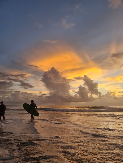Surfers walking the beach at sunset, Playa Avellanas, Costa Rica