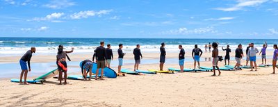 A surf lesson lined up with boards on the sand at Playa Avellanas, three minutes from Johnny's Beach Bungalow, Guanacaste, Costa Rica
