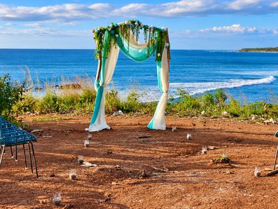 A wedding arch on the bluff above the sand